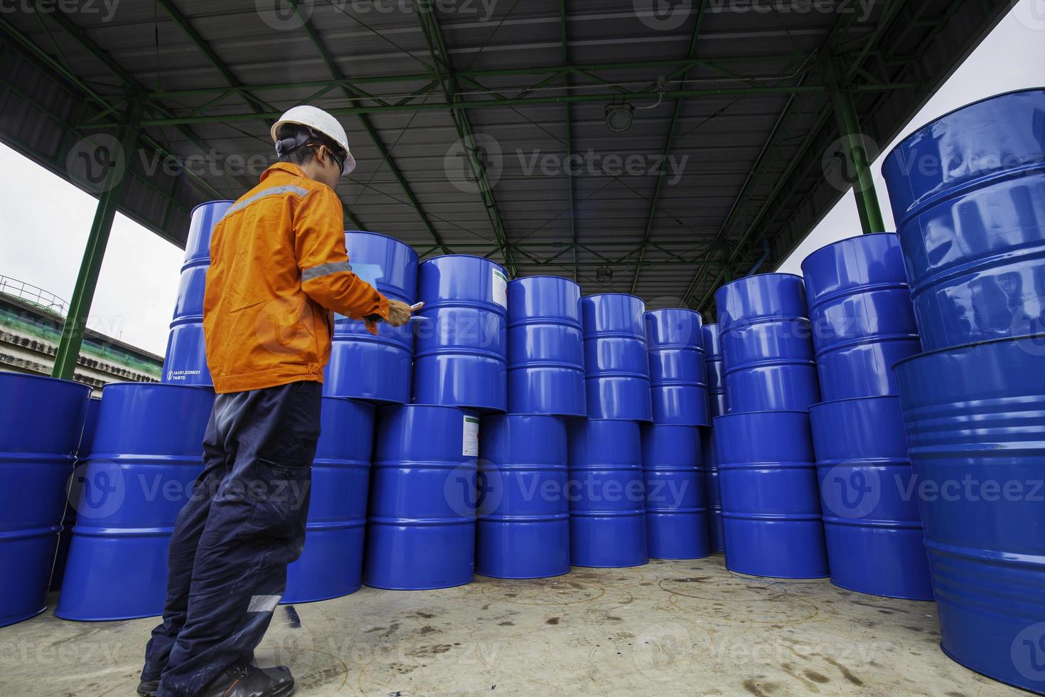 mannelijke werknemer inspectie record drum olie voorraad vaten blauw horizontaal of chemisch foto