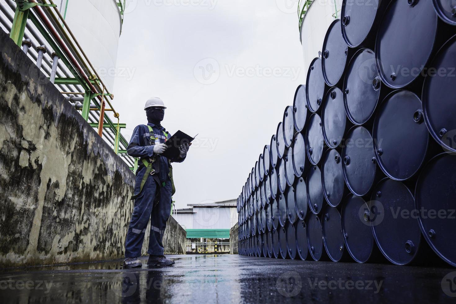 mannelijke werknemer inspectie record drum olie voorraad vaten blauw horizontaal of chemisch foto