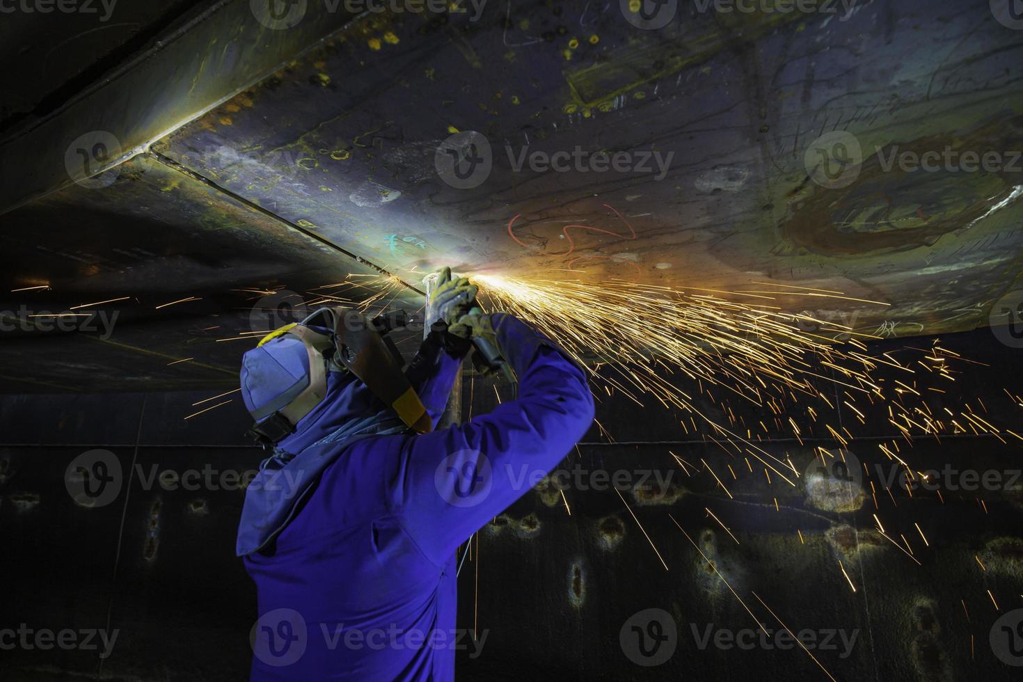 mannelijke werknemer slijpen op stalen plaat met vonkenflits close-up draag beschermende handschoenen foto