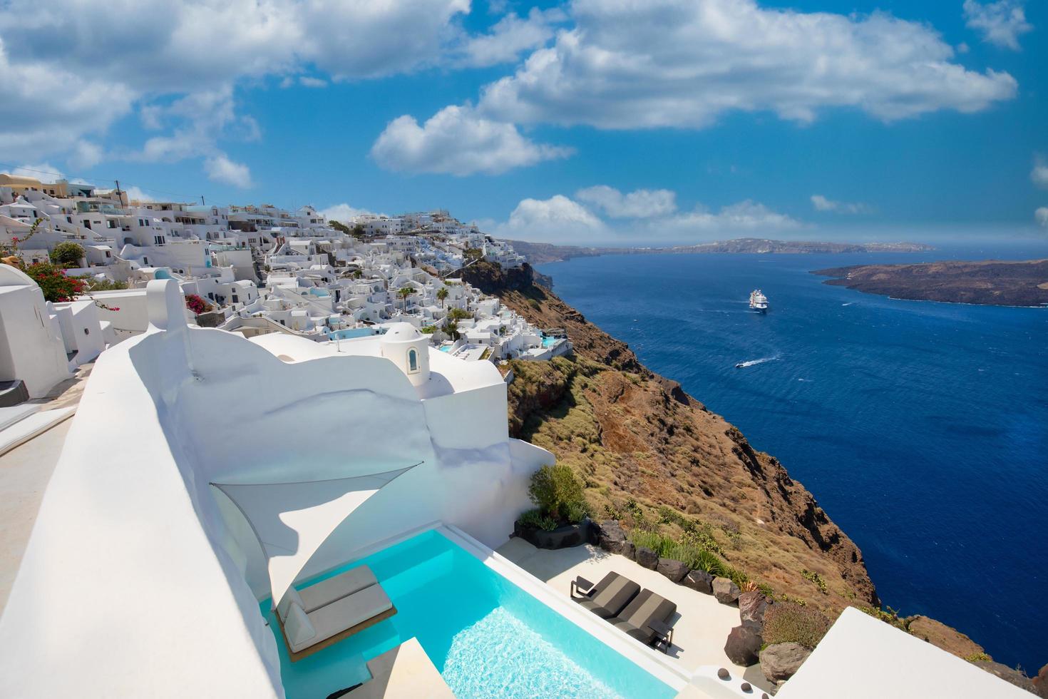 06.05.19 - Santorini-eiland, Griekenland. luxe privé leeg overloopzwembad over de caldera, uitzicht op zee, cruiseschip op blauwe zee baai. zomervakantie, reislandschap foto