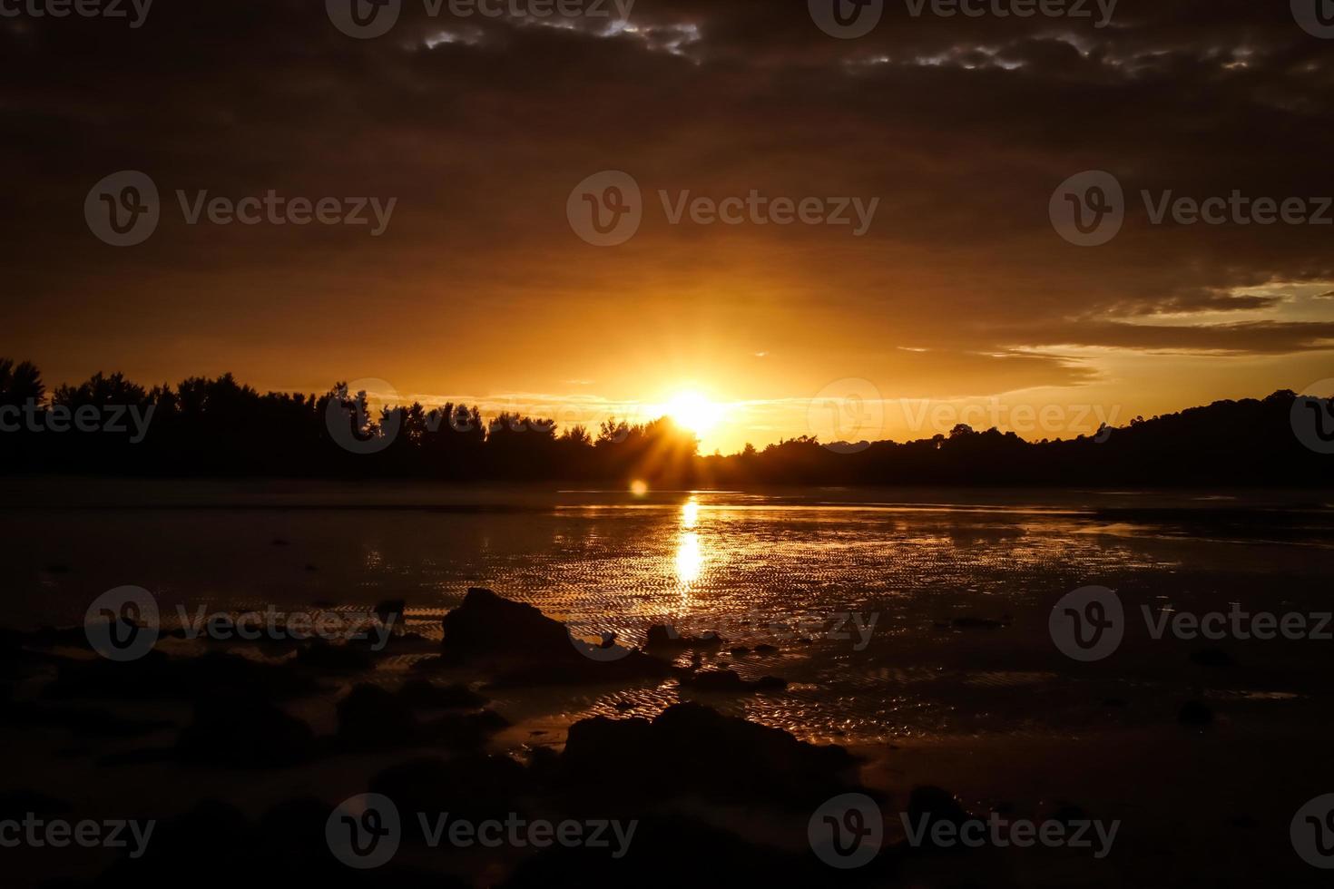 prachtige zonsondergang op het strand en de zon wordt weerspiegeld op de golven. foto