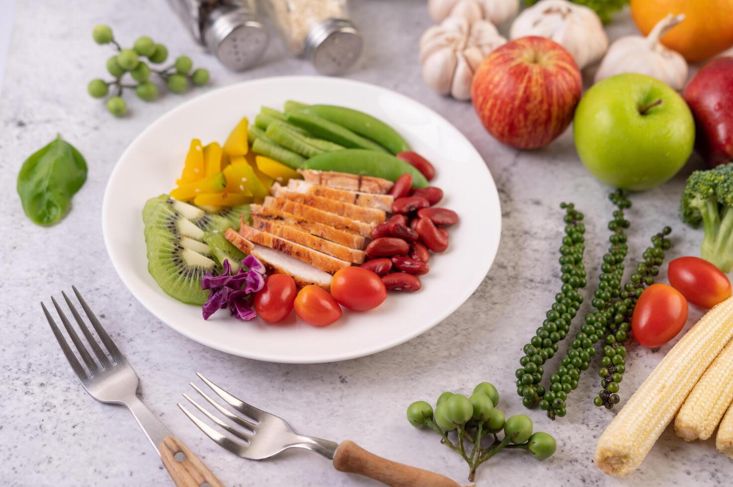 kippenbiefstuk met erwten, tomaten, kiwi en pompoen. foto