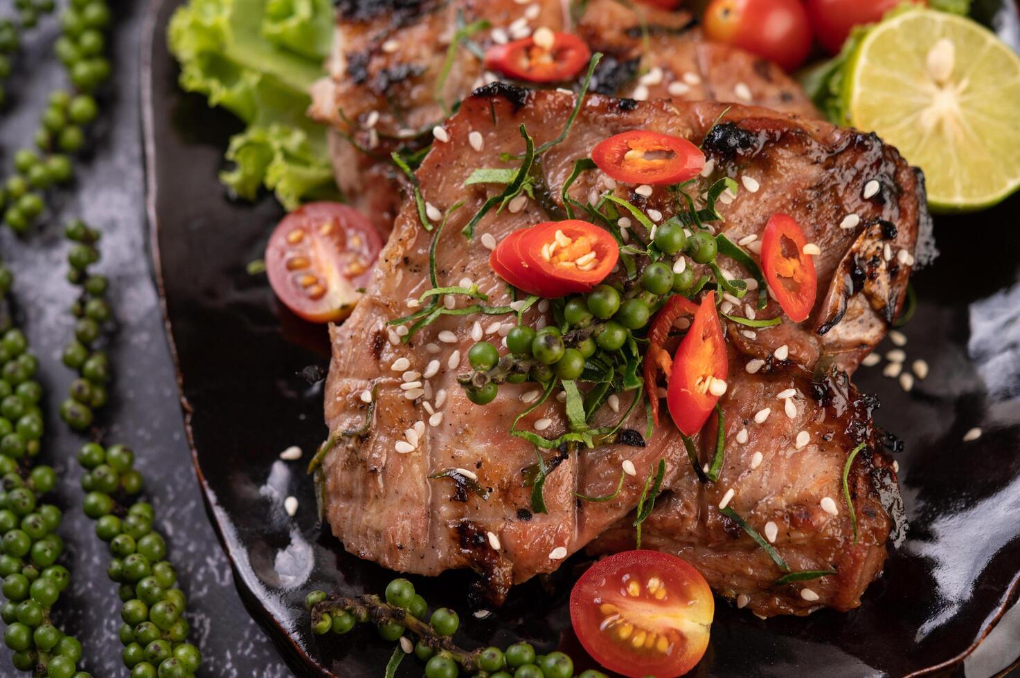 varkenssteak gegarneerd met witte sesam en verse peperzaadjes. foto