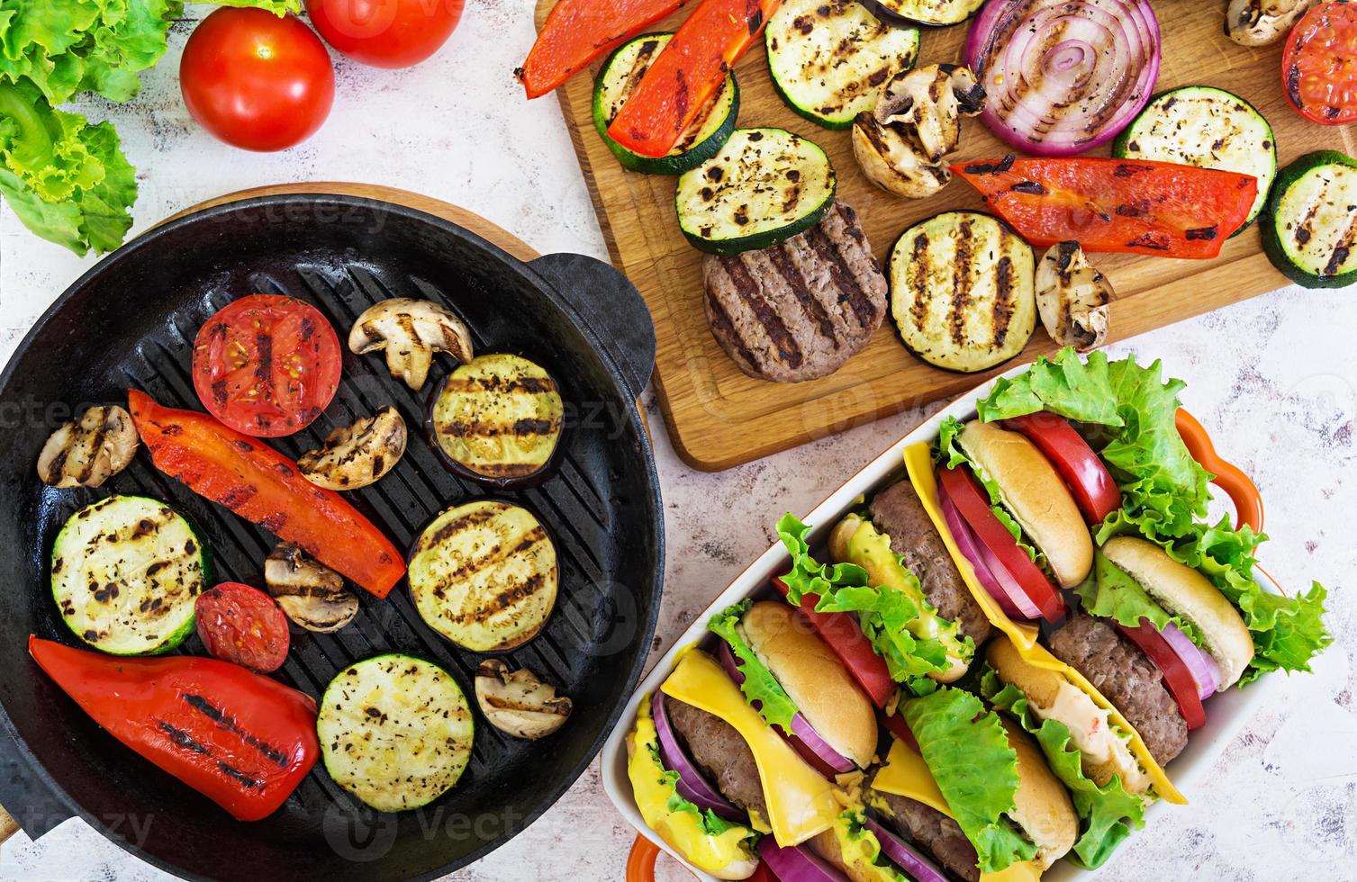 gegrilde groenten en handgemaakte hamburger. courgette, aubergine, champignons, peper op de grill. bovenaanzicht foto