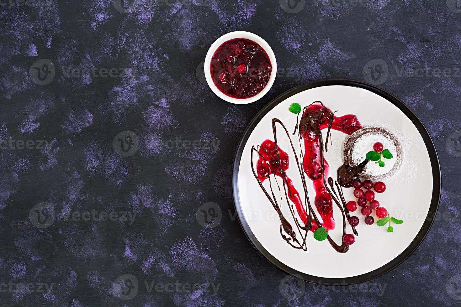 chocolade fondant met cranberrysaus. bovenaanzicht. foto