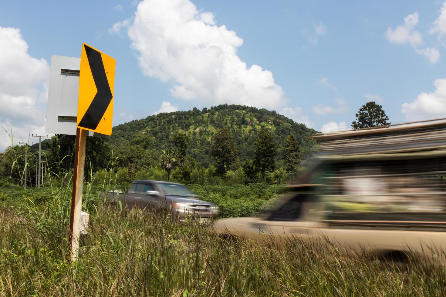 auto's passeren wegwijzer bochten. foto