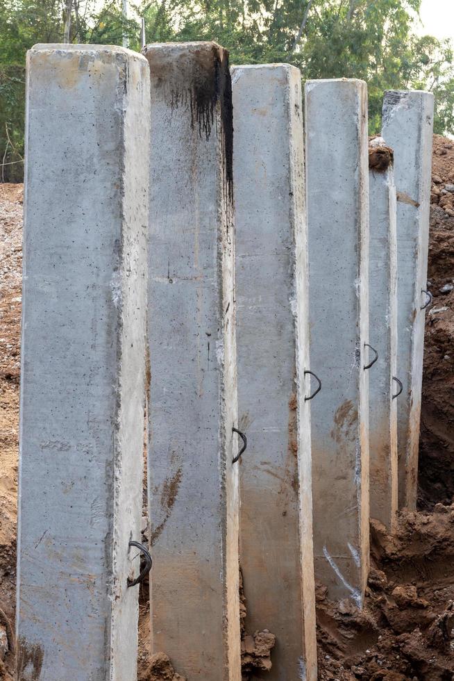 veel betonnen palen in de uitgegraven grond voor de bouw. foto