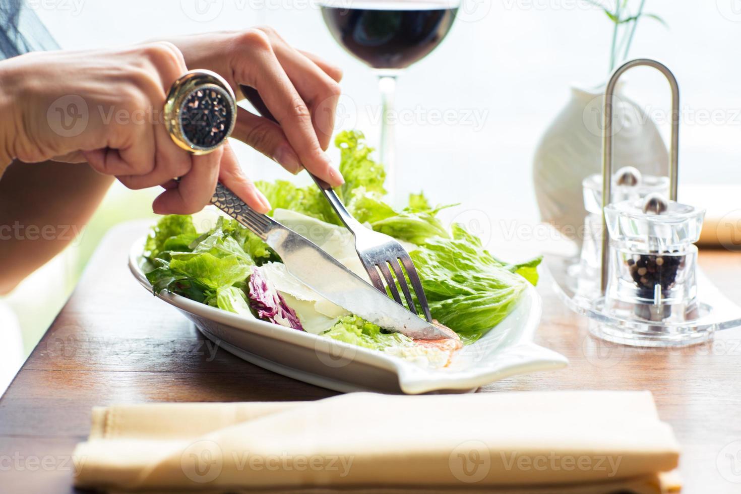 vrouwelijke handen die salade eten foto