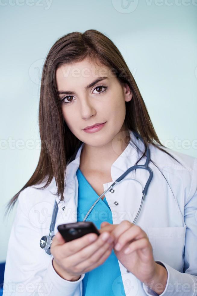 jonge vrouwelijke arts sms'en foto