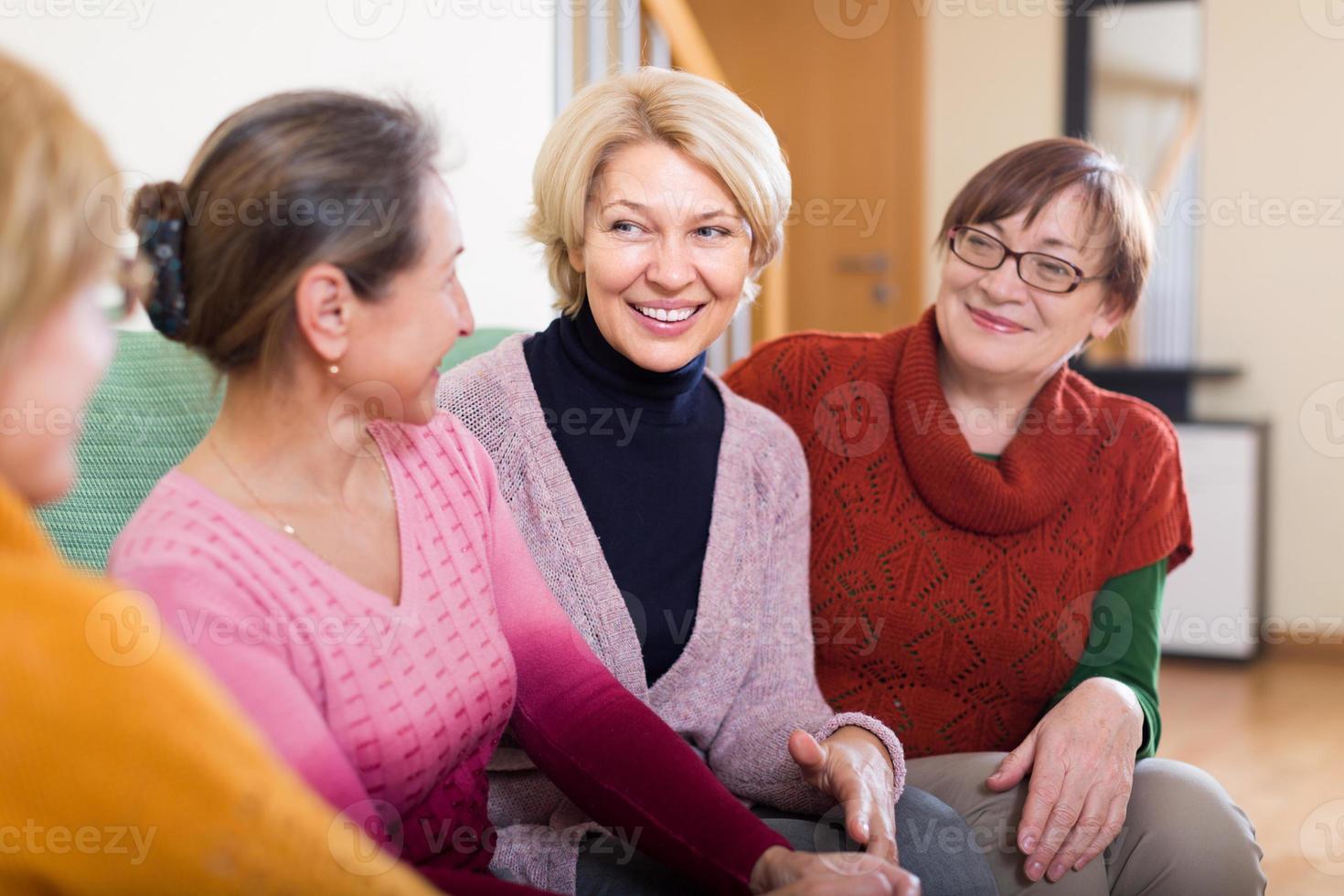glimlachende vrouwelijke gepensioneerden op bank foto