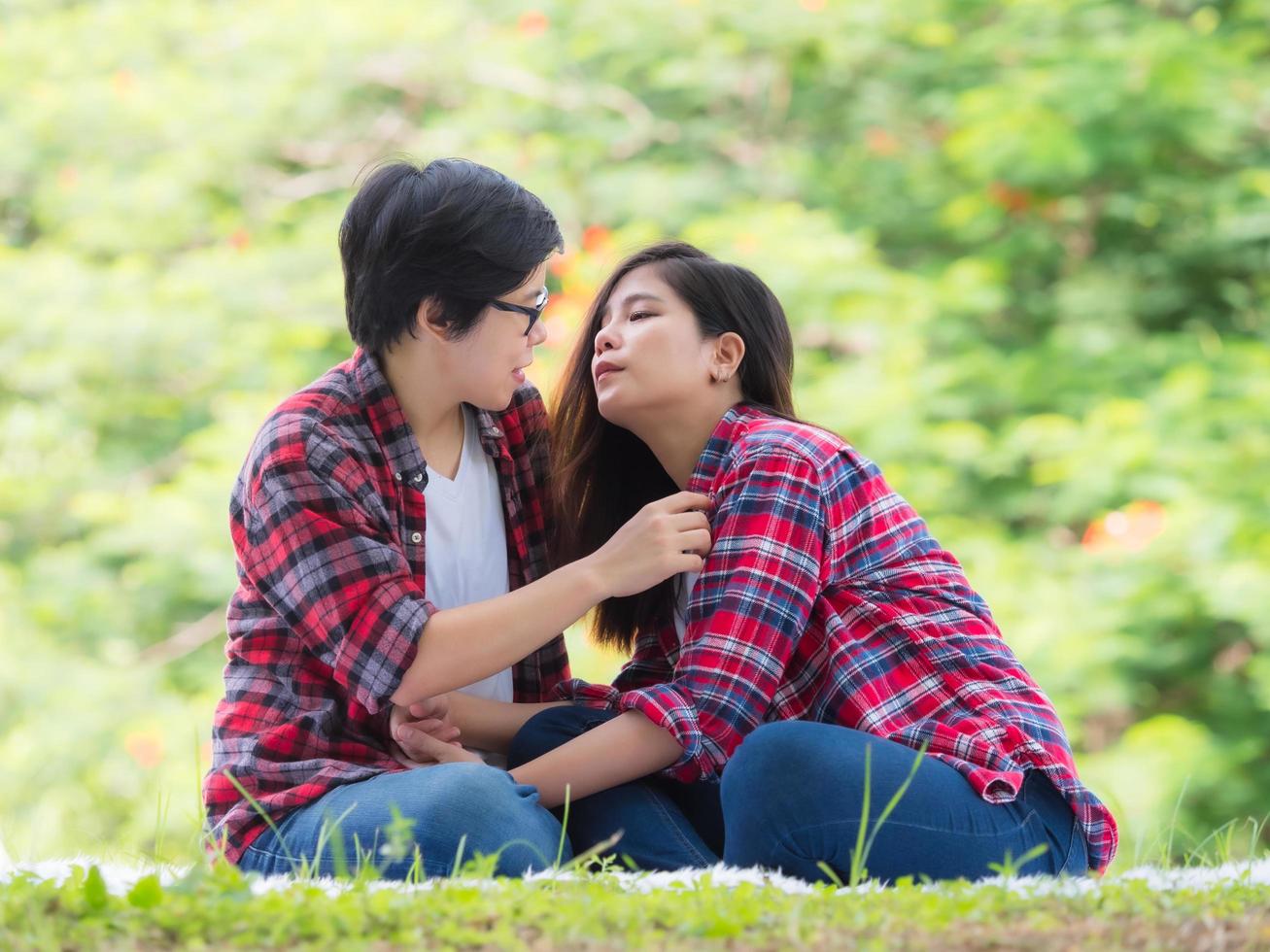 Aziatische vrouwelijke stellen lgbt zitten en ontspannen in de tuin en omhelzen elkaar in liefde en geluk foto