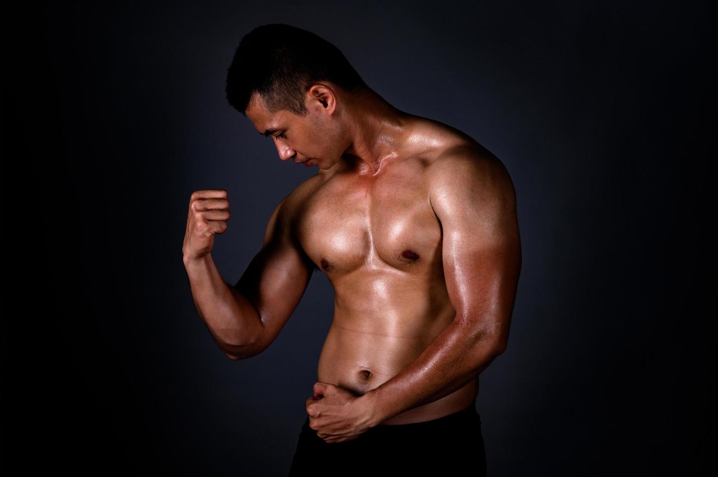 een sterke Aziatische man hief zijn armen op om zijn sterke en mooie spieren te laten zien van het sporten foto