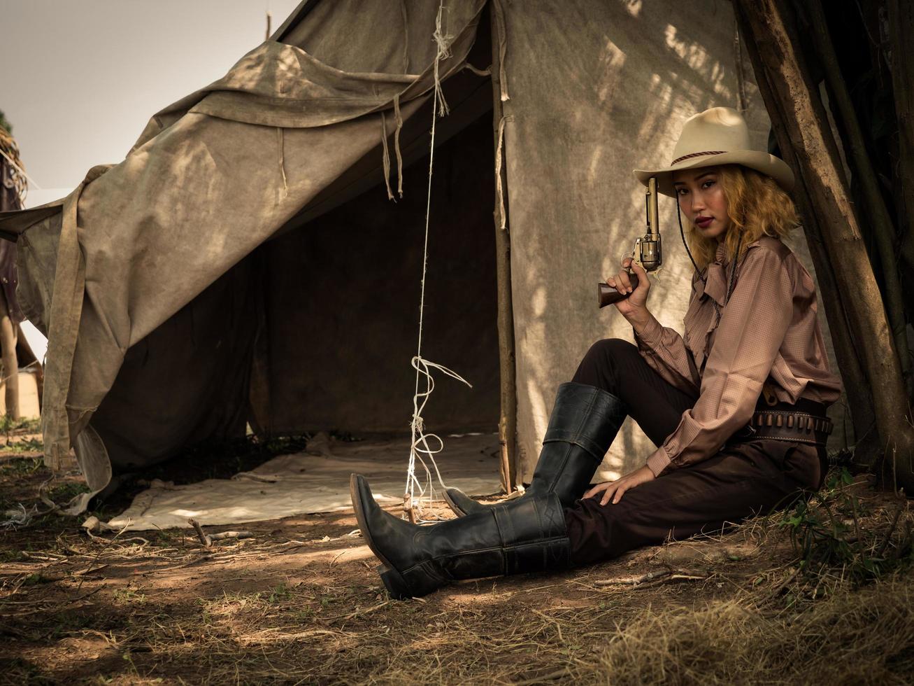 een jonge cowgirl zat met een pistool om de veiligheid van het kamp in het westelijke gebied te bewaken foto