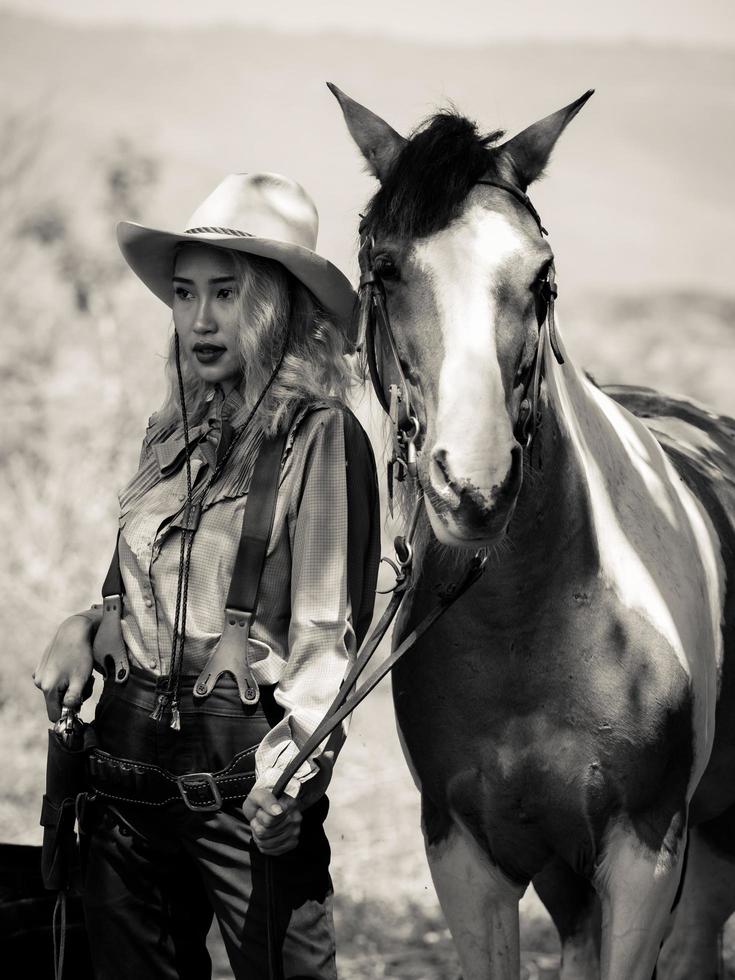 een jonge cowgirl staat met een pistool om de veiligheid van het kamp in het westen te bewaken foto