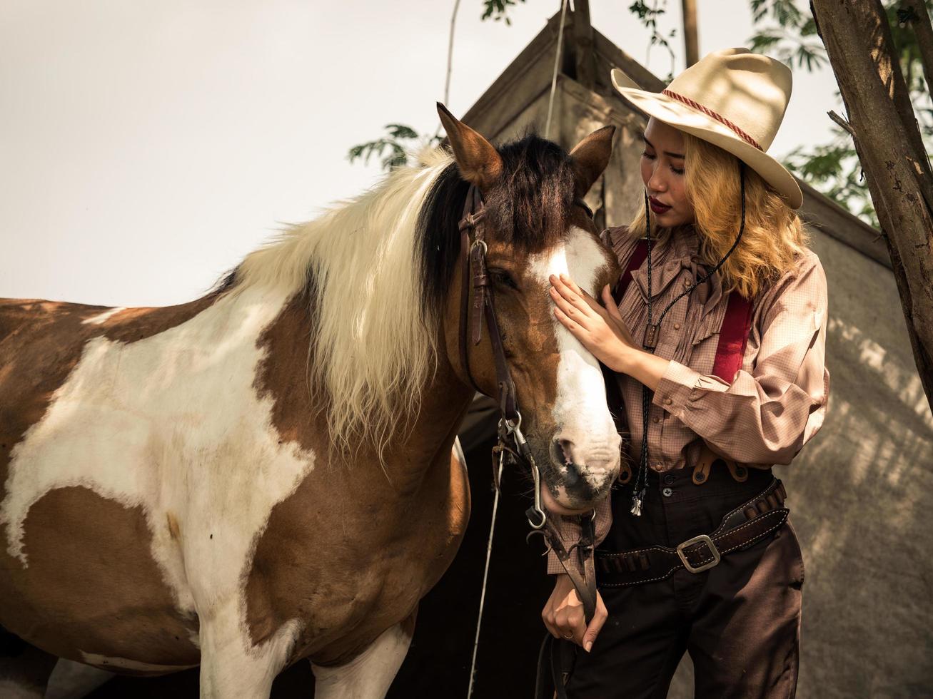 cowgirl raakt het paard met liefde aan vanwege relaties die vrienden zijn die samen lijden en geluk delen foto