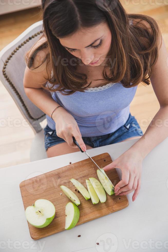jonge vrouwelijke snijden apple.image van bovenaf. foto