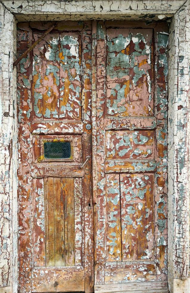 oude gebarsten bruine deur aan de voorkant van het huis foto