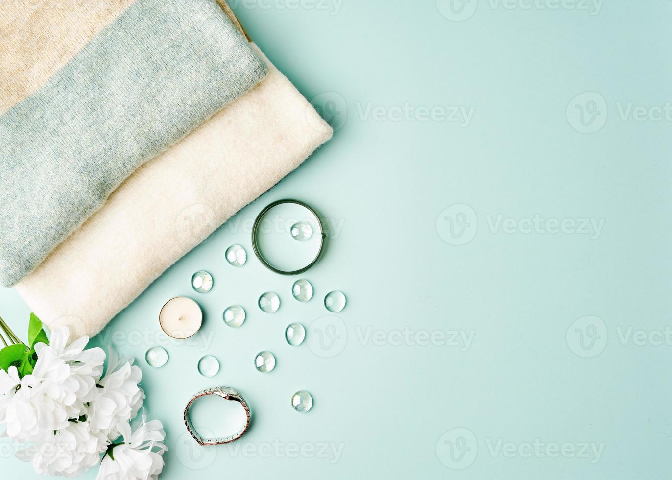 plat lag vrouw accessoires met trui op pastel blauwe tafel, kopieer ruimte. foto