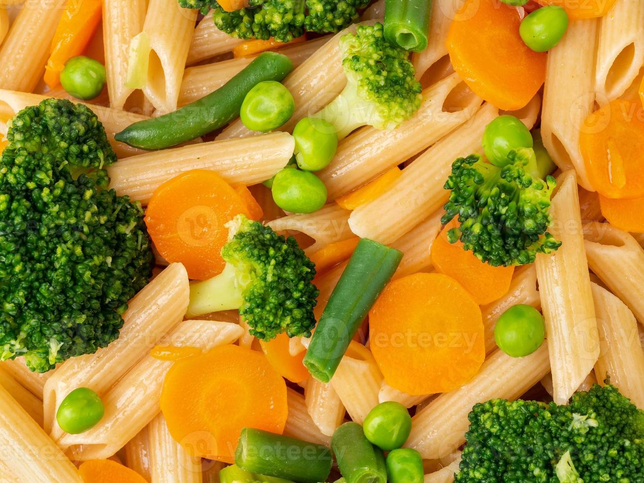 volkoren pasta penne met broccoli, wortelen, doperwtjes. close-up, macro. dieetmenu foto