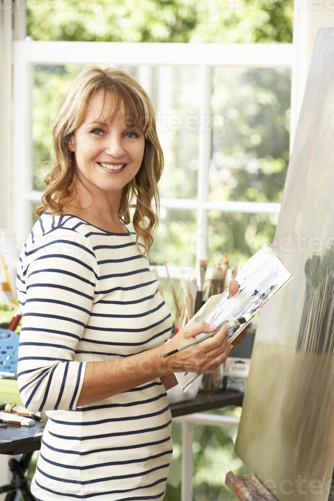 vrouwelijke kunstenaar bezig met schilderen in studio foto