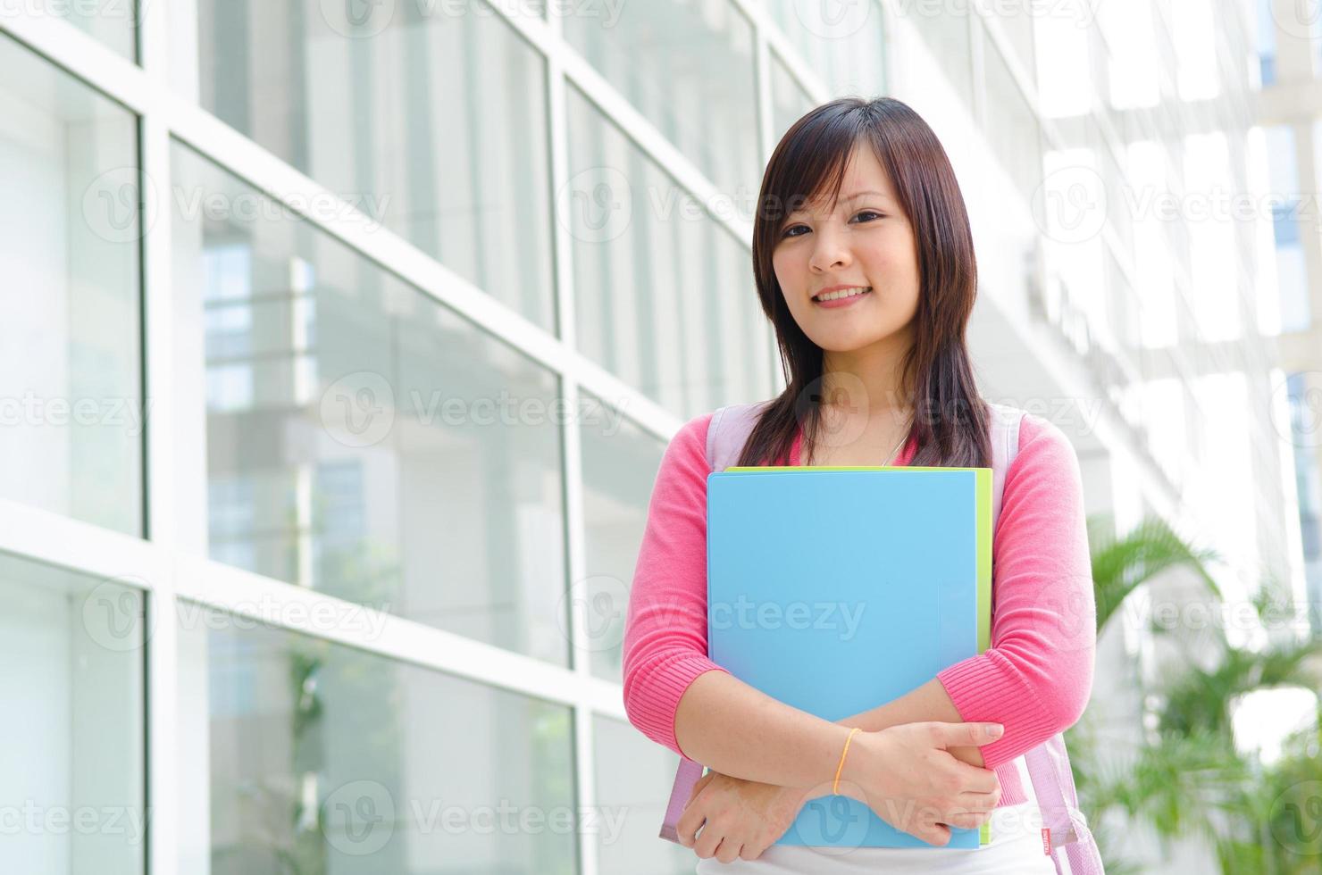 Aziatische Chinese college vrouwelijke student met campus achtergrond foto