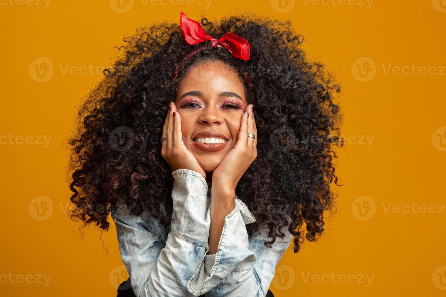 schoonheidsportret van afrikaanse amerikaanse vrouw met afrokapsel en glamourmake-up. Braziliaanse vrouw. gemengd ras. gekruld haar. kapsel. gele achtergrond. foto