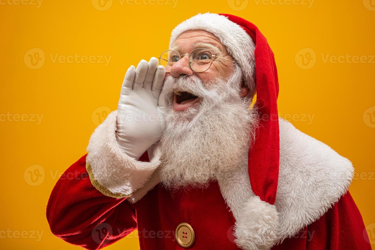 communicatieconcept. profiel zijaanzicht foto van opgewonden grappige vriendelijke stijlvolle kerstman met open mond houd palm hand in de buurt van gezicht zeggen luid ho-ho-ho geïsoleerd op levendige gele achtergrond