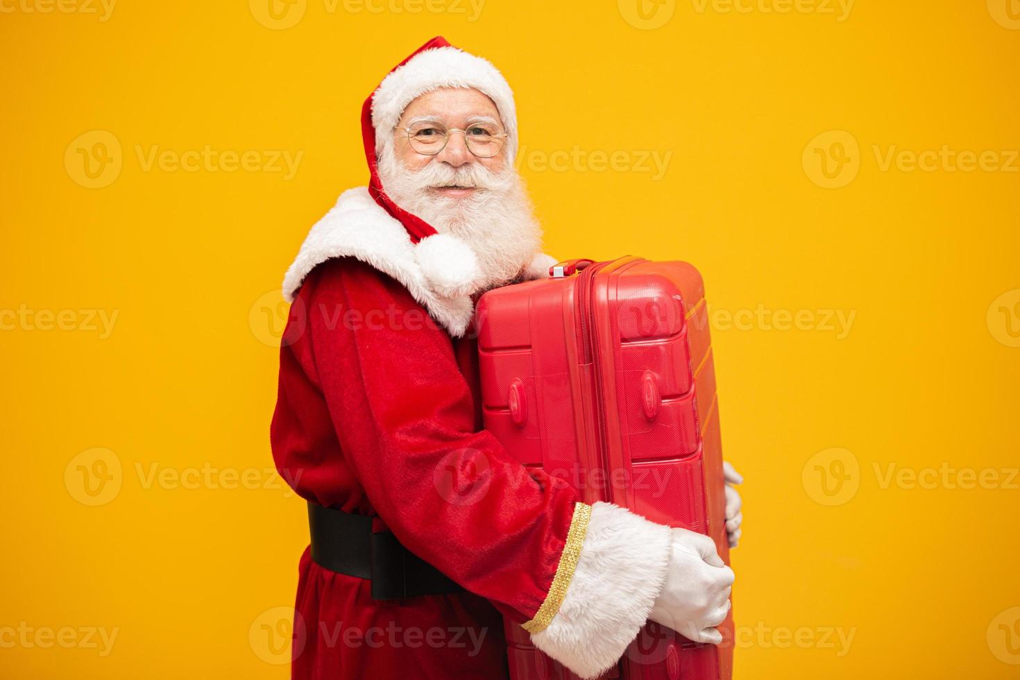 kerstman met zijn koffer. nieuwjaarsreisconcept. kerstman op de luchthaven. foto