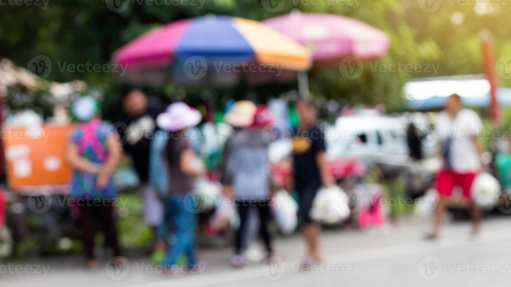 wazige mensen staan en lopen op de markt. foto