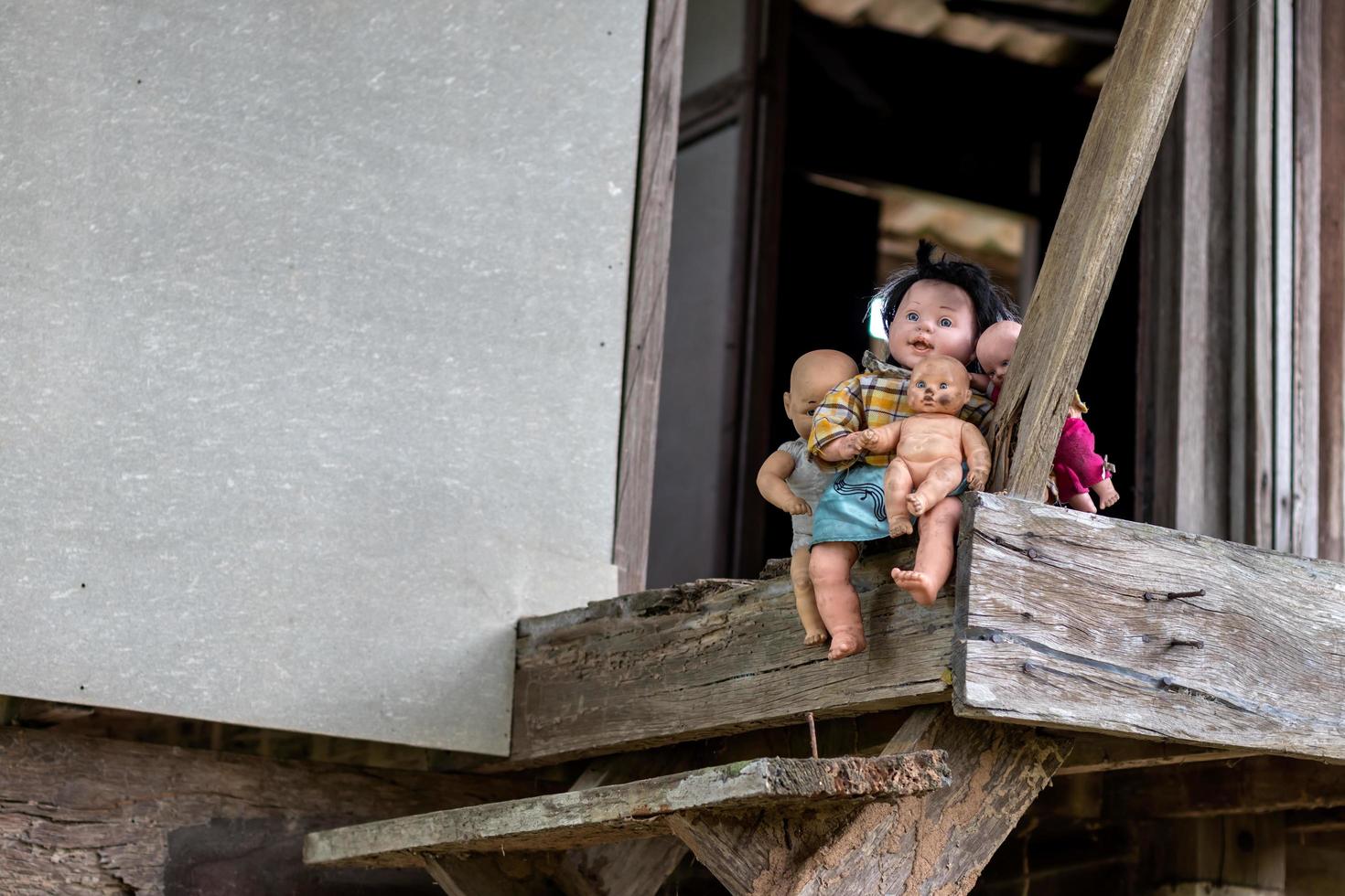 veel babypoppen zitten op oude houten huisbalkons. foto