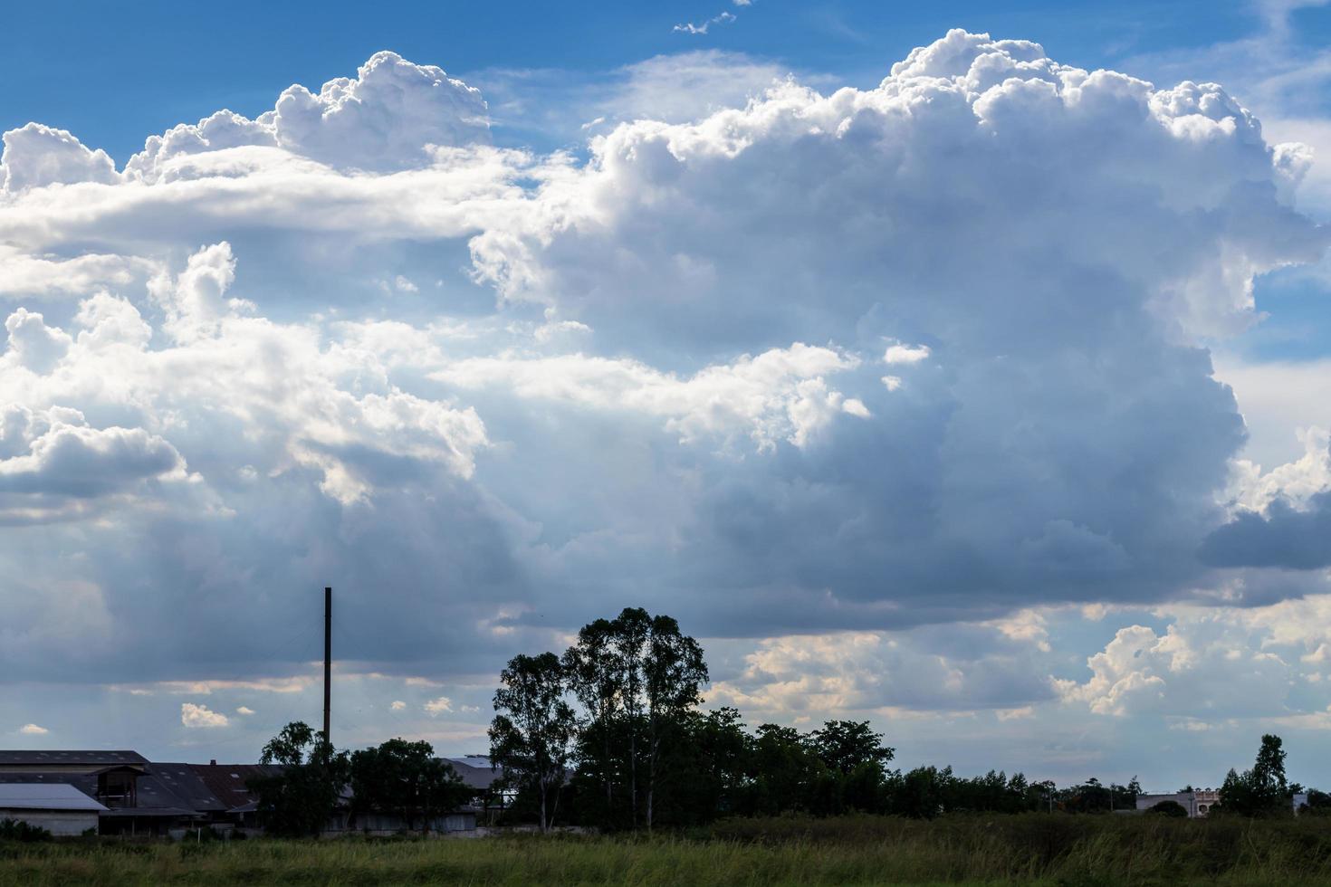 bewolkte wolken in de lucht boven de bomen die op het platteland van thailand leven. foto