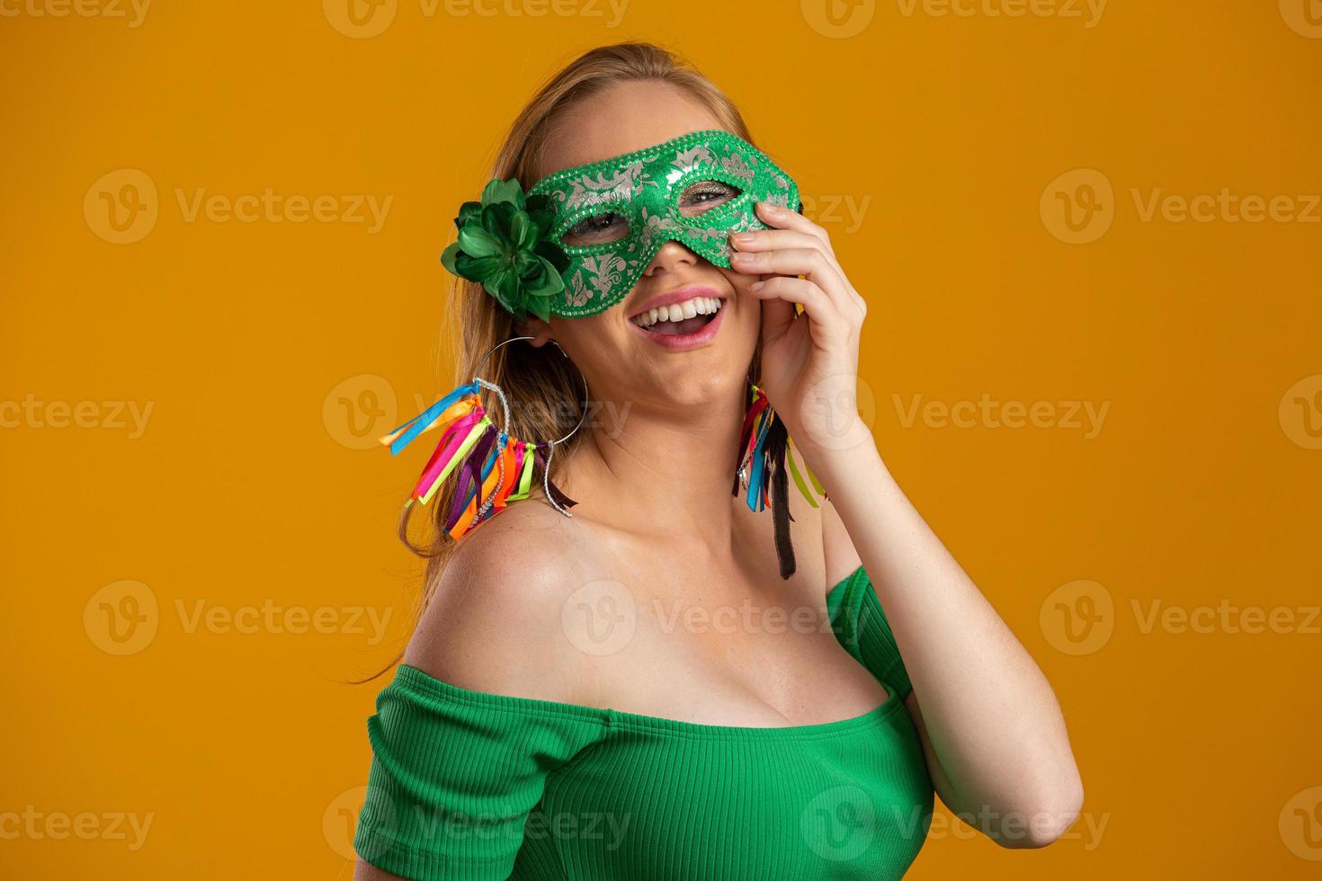 mooie vrouw gekleed voor carnaval nacht. lachende vrouw klaar om te genieten van het carnaval met een kleurrijk masker. foto