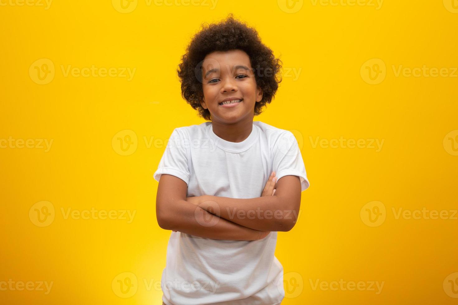 Afro-Amerikaanse jongen met zwart machtshaar op gele achtergrond. lachende zwarte jongen met een zwart machtshaar. zwarte jongen met zwart powerhaar. Afrikaanse afkomst. foto