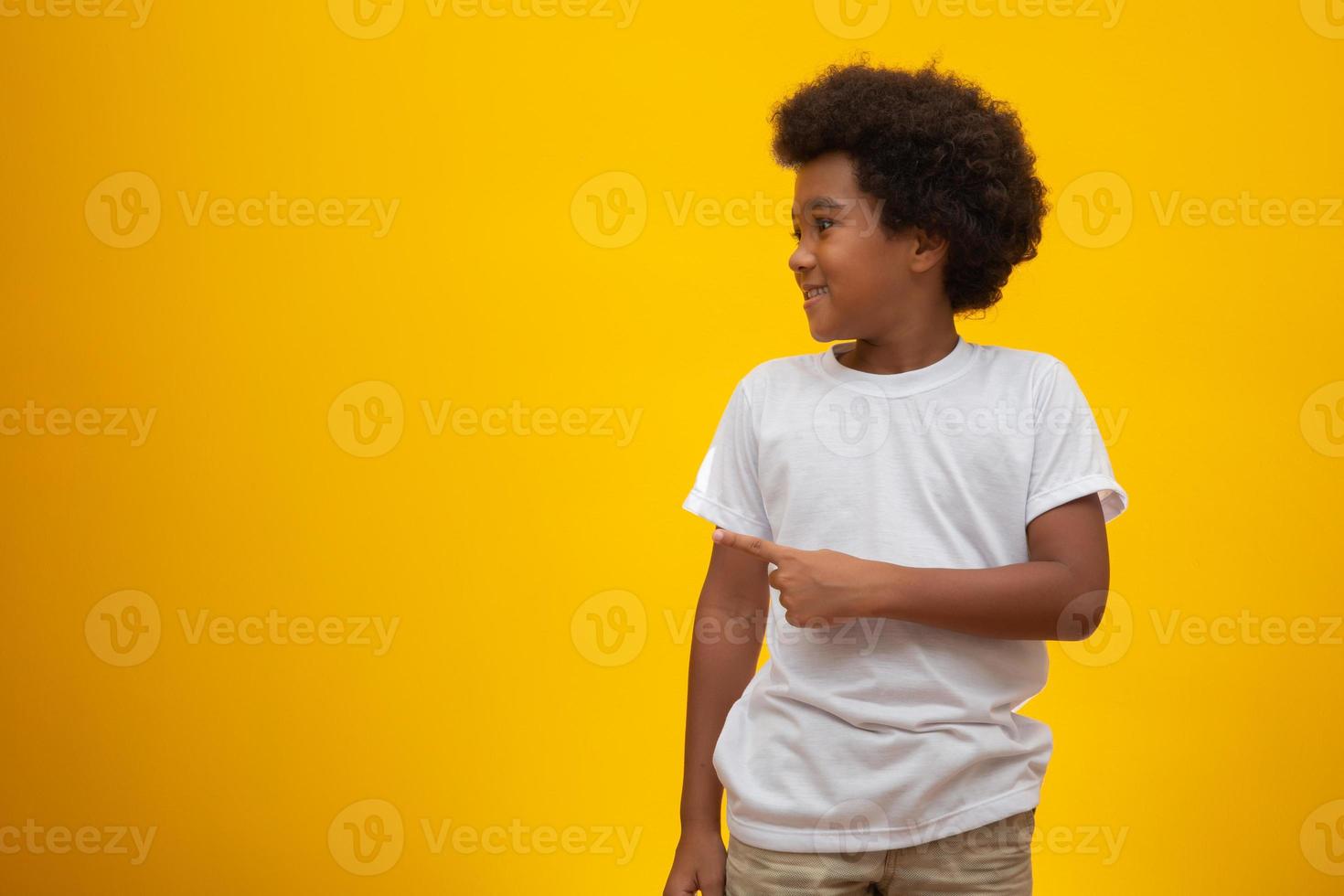 Afro-Amerikaanse jongen met zwart machtshaar op gele achtergrond. lachende zwarte jongen met een zwart machtshaar. zwarte jongen met zwart powerhaar. Afrikaanse afkomst. foto