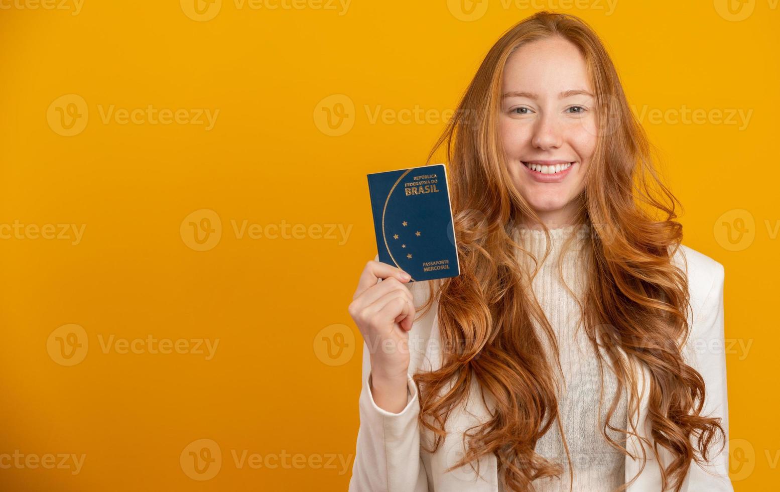 mooie roodharige krullend meisje in reizen. volgende reis. meisje met Braziliaans paspoort. op geel. foto