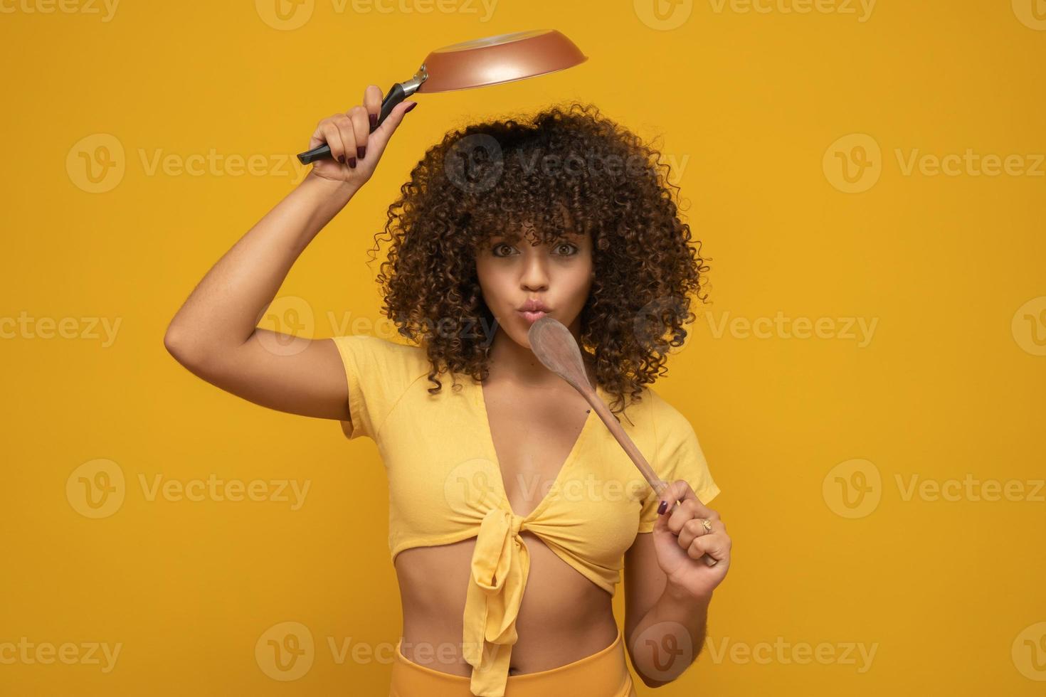 kookgerei. kokende vrouw in keuken met pan en houten lepel. huisvrouw dansen. foto