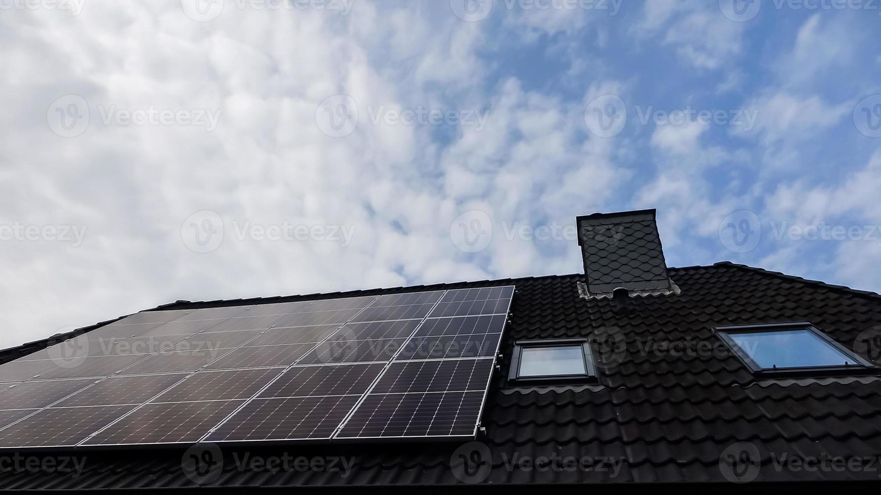 zonnepanelen die schone energie produceren op een dak van een woonhuis foto