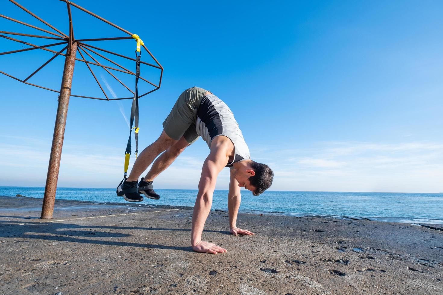 fit mannelijke training in de zomer, oefeningen met ophangbanden buitenshuis foto