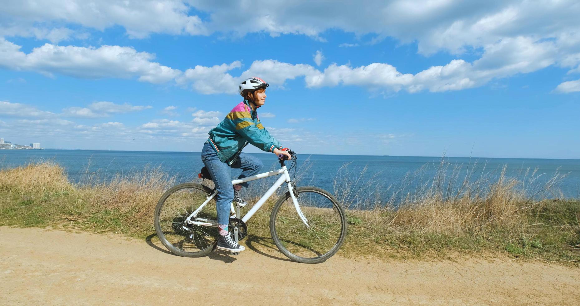 jonge vrouw fietser in helm in zonnige zomerdag foto