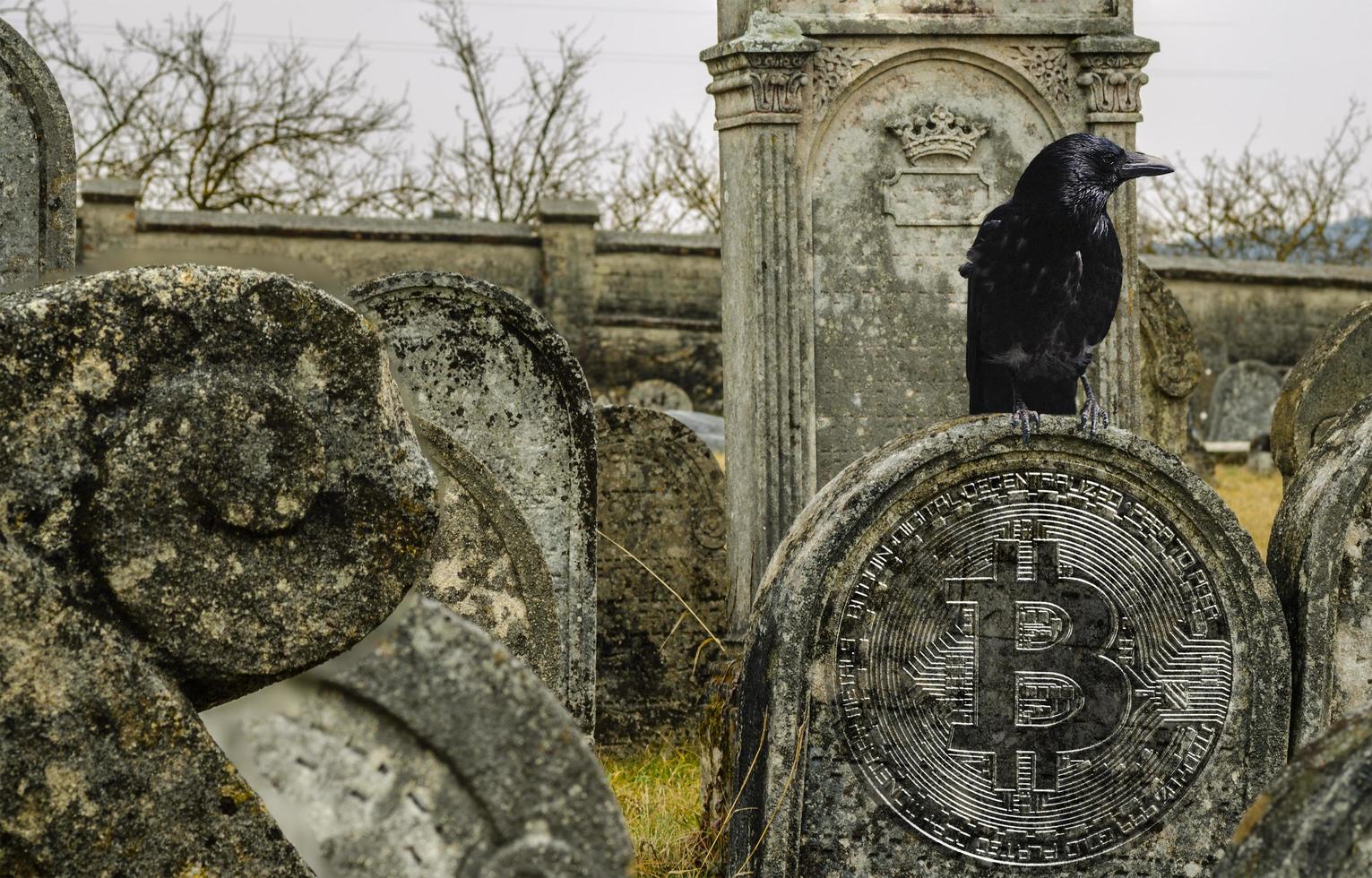 oude grafstenen met een zilveren bitcoin dalende cryptomarkt en donaties tijdens oorlog foto