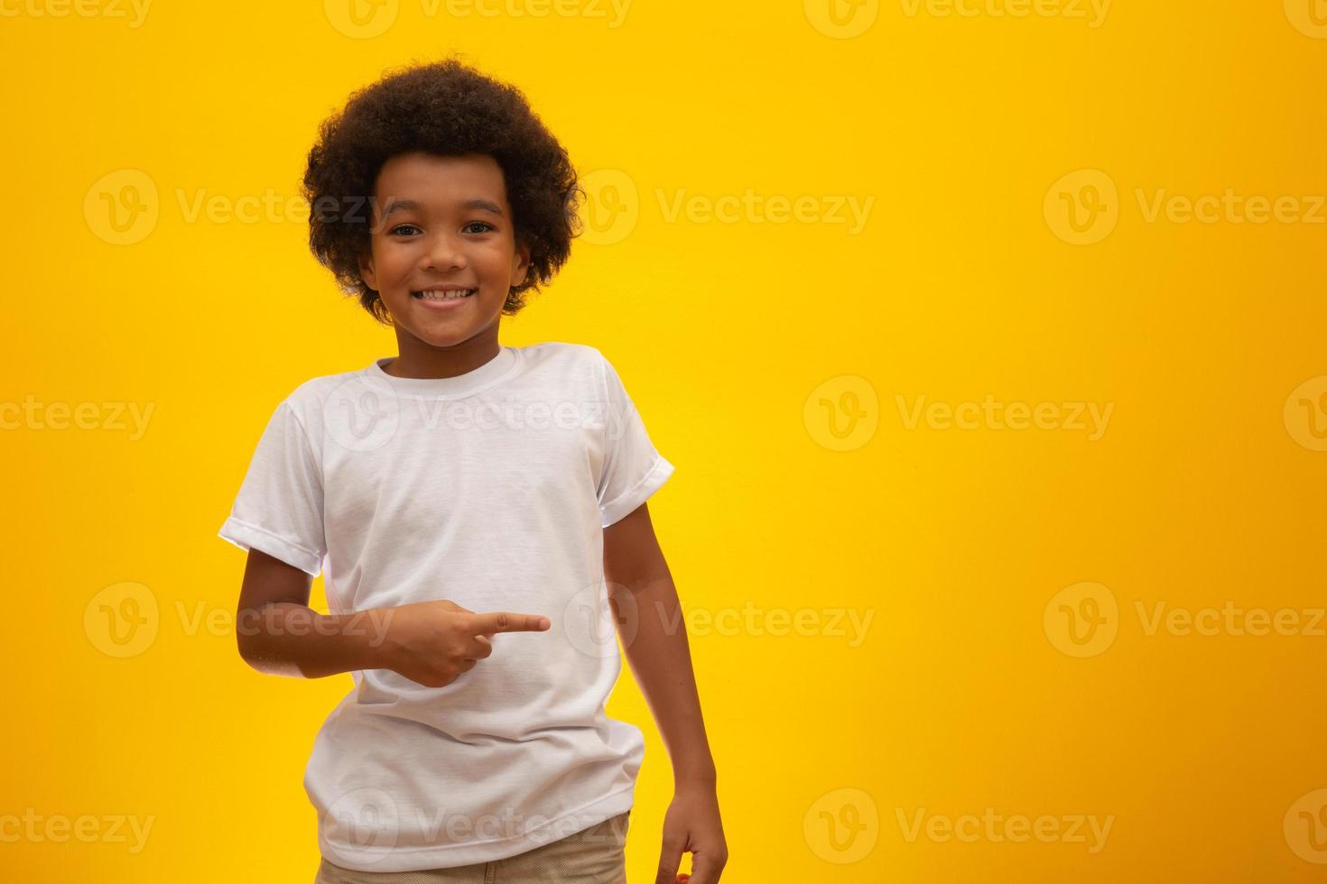 Afro-Amerikaanse jongen met zwart machtshaar op gele achtergrond. lachende zwarte jongen met een zwart machtshaar. zwarte jongen met zwart powerhaar. Afrikaanse afkomst. foto