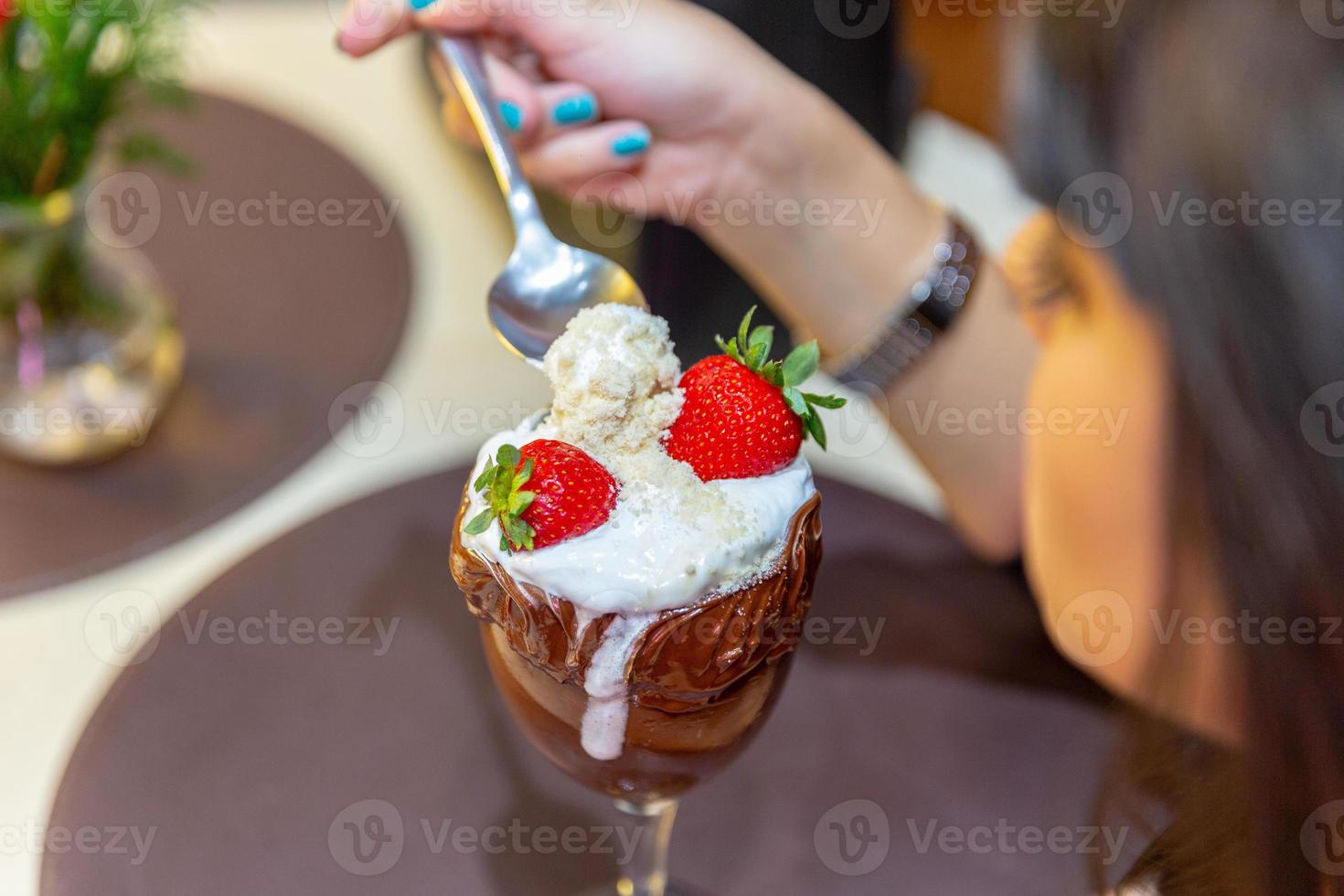 ijswit combineert aardbei met hoge calorieën, kan je dik maken, zachte focus, wazig. heerlijke vanille of chocolade ijscoupe met aardbei. foto