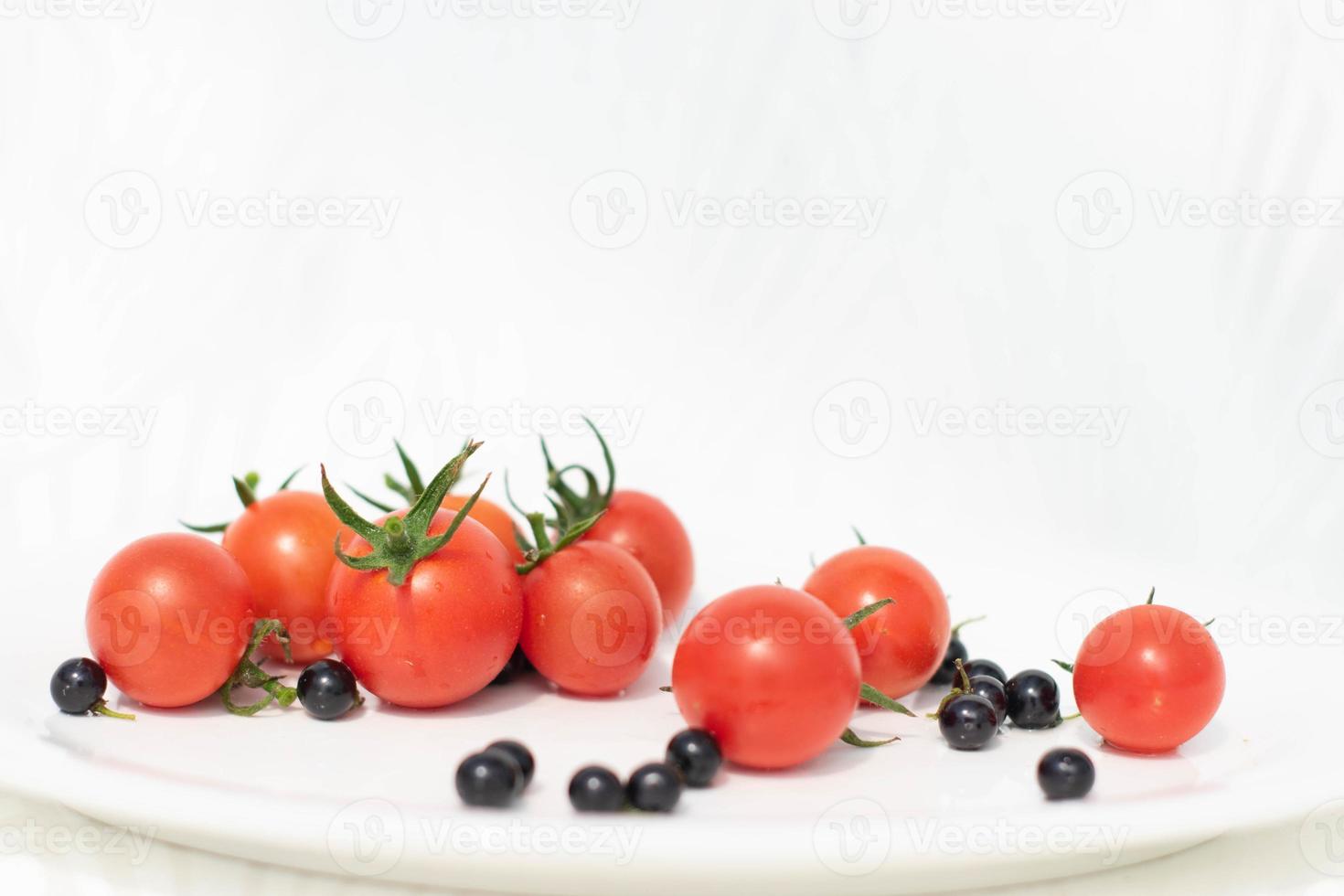 verse rode tomaten met bramen op thite achtergrond, gezonde voeding voor gezond eten. foto