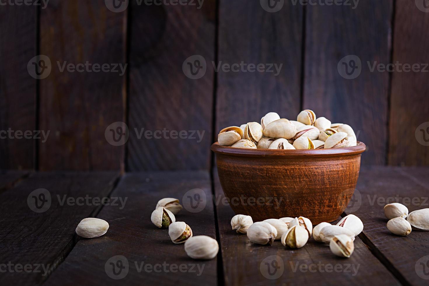 pistachenoten op houten achtergrond. geroosterde gezouten pistachenoten. foto