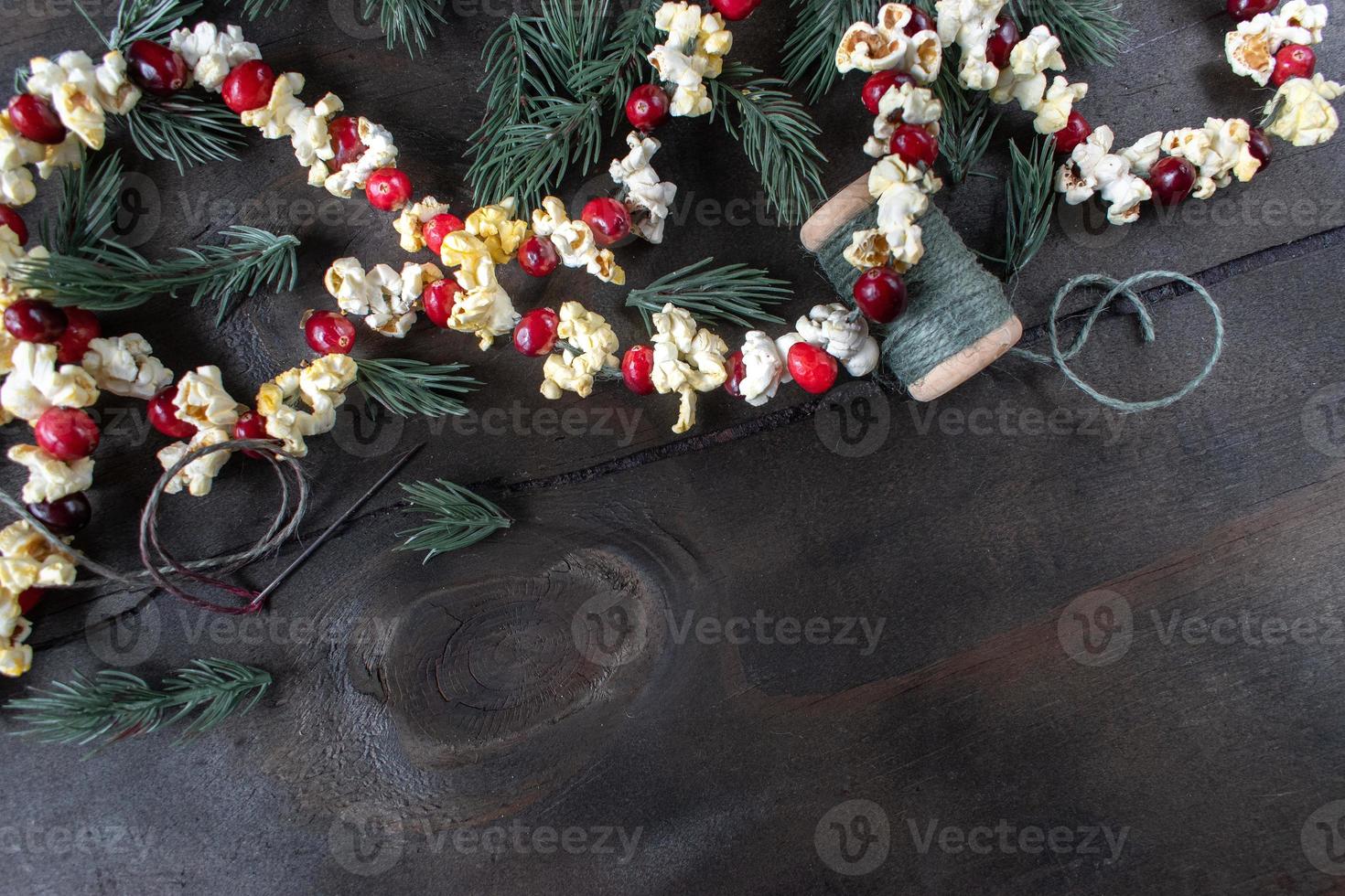 kerstslinger van rode veenbessen en popcornpitten met kopieerruimte foto