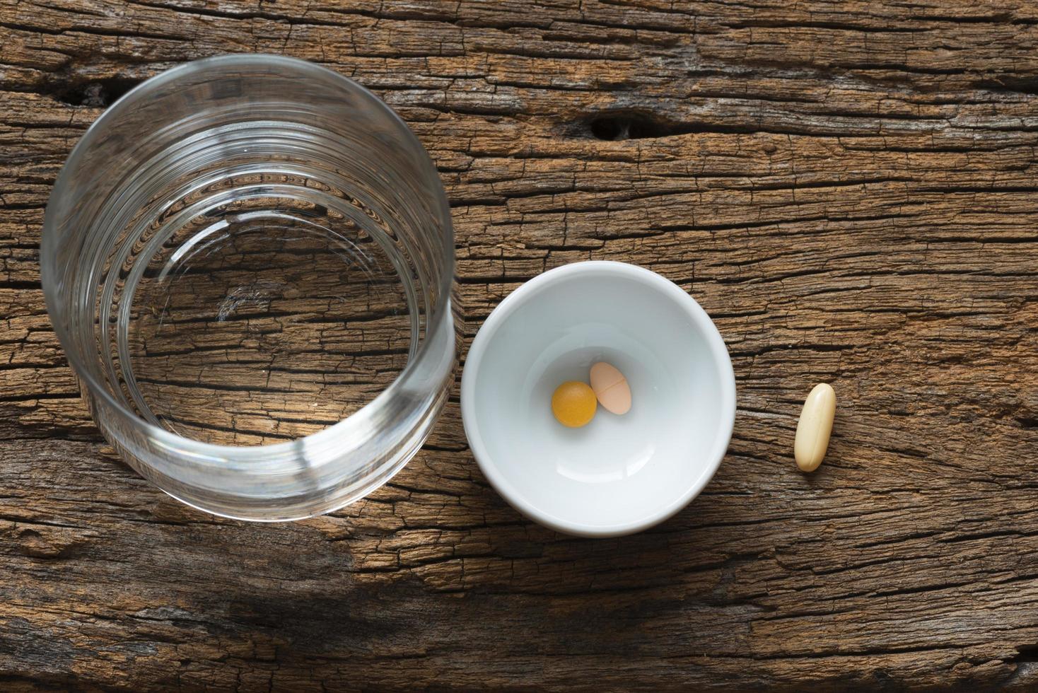 bovenaanzicht van medicijnen en een glas water foto