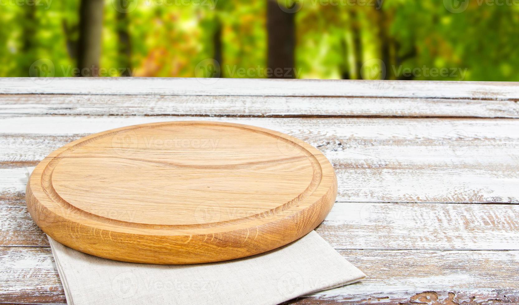leeg pizzabord op lege houten tafel met tafelkleed, servet - bovenaanzicht foto