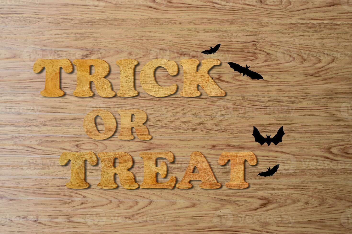 trick or treat geschreven met houten letters over het oppervlak van bruine houten planken. foto