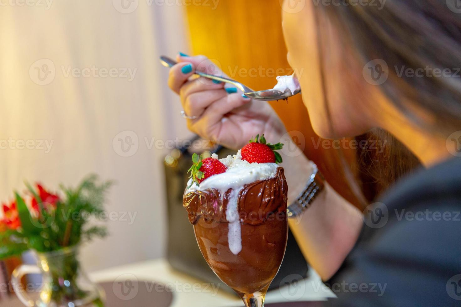 ijswit combineert aardbei met hoge calorieën, kan je dik maken, zachte focus, wazig. heerlijke vanille of chocolade ijscoupe met aardbei. foto