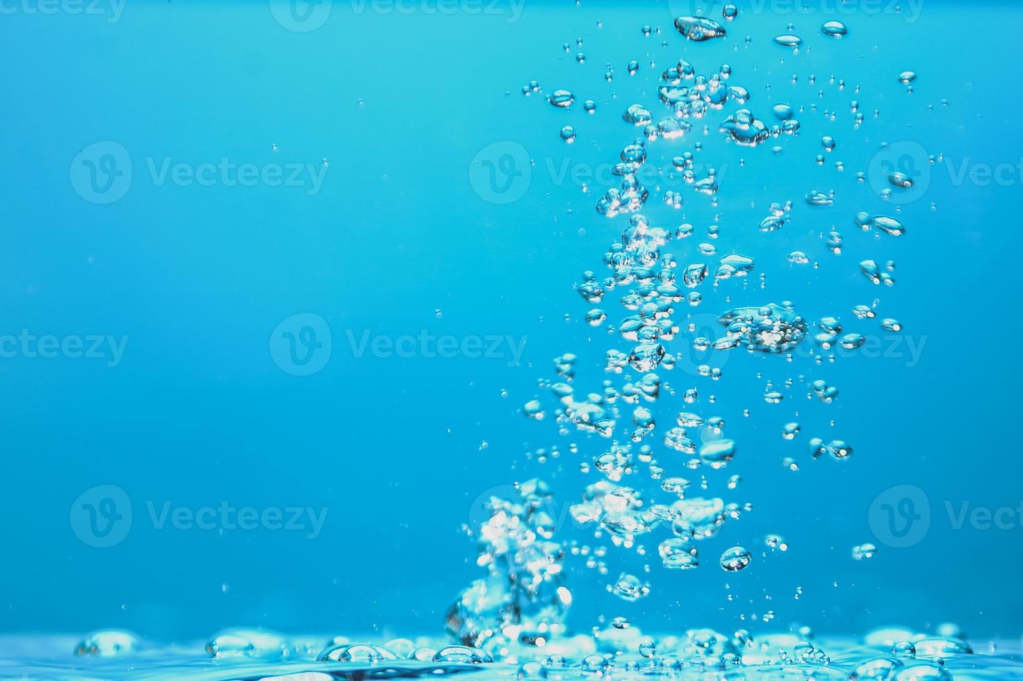 abstracte achtergrondafbeelding van bellen in water. schoon water met waterdruppels en golven. zoet water een glas met bubbels blauwe achtergrond. foto